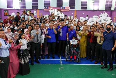 Annuar (tengah) bersama pelajar Tingkatan Enam dalam Daerah Bagan Datuk yang menerima Peranti Siswa Keluarga Malaysia di Sekolah Menengah Kebangsaan Tun Abdul Razak (STAR) Selekoh, Bagan Datuk pada Selasa. - Foto Bernama