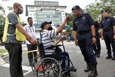 Ketua Polis Selangor, Datuk Arjunaidi Mohamed (dua dari kanan) beramah mesra bersama pesara polis Sarjan Azmi Abdul Rani yang berkerusi roda selepas menjalankan tanggungjawab mengundi awal sempena Pilihan Raya Umum ke-15 (PRU15) di Dewan Utama Ibu Pejabat Polis Kontinjen Selangor, pada Selasa. - Foto Bernama