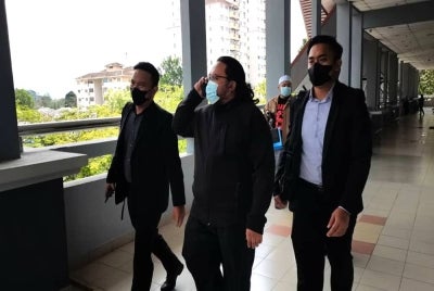 Mohd Hasbollah (tengah) diiring pegawai SPRM di Mahkamah Sesyen Seremban pada Selasa.