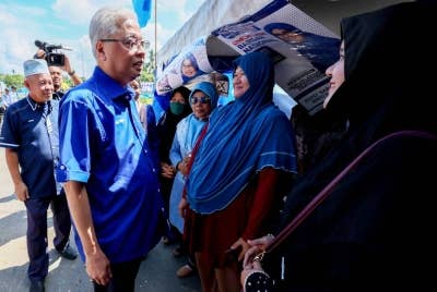 Ismail Sabri (dua dari kiri) yang juga calon BNbagi Parlimen P090 Bera beramah mesra bersama penduduk di Bilik Gerakan Kg Durian Tawar pada Rabu. - Foto Bernama