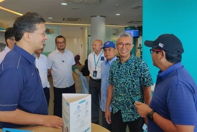 Tengku Zafrul (dua dari kanan) berbincang sesuatu pada lawatannya ke BSN di sini pada Rabu.