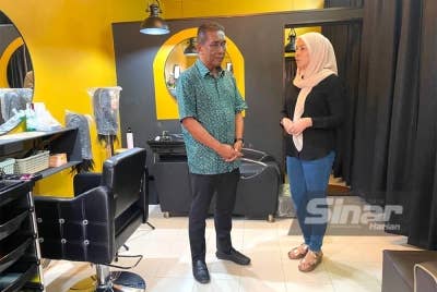 Takiyuddin (kiri) bertemu seorang pengusaha salon, Vivi Sumanthi di Bazar Tok Guru, Kota Bharu.
