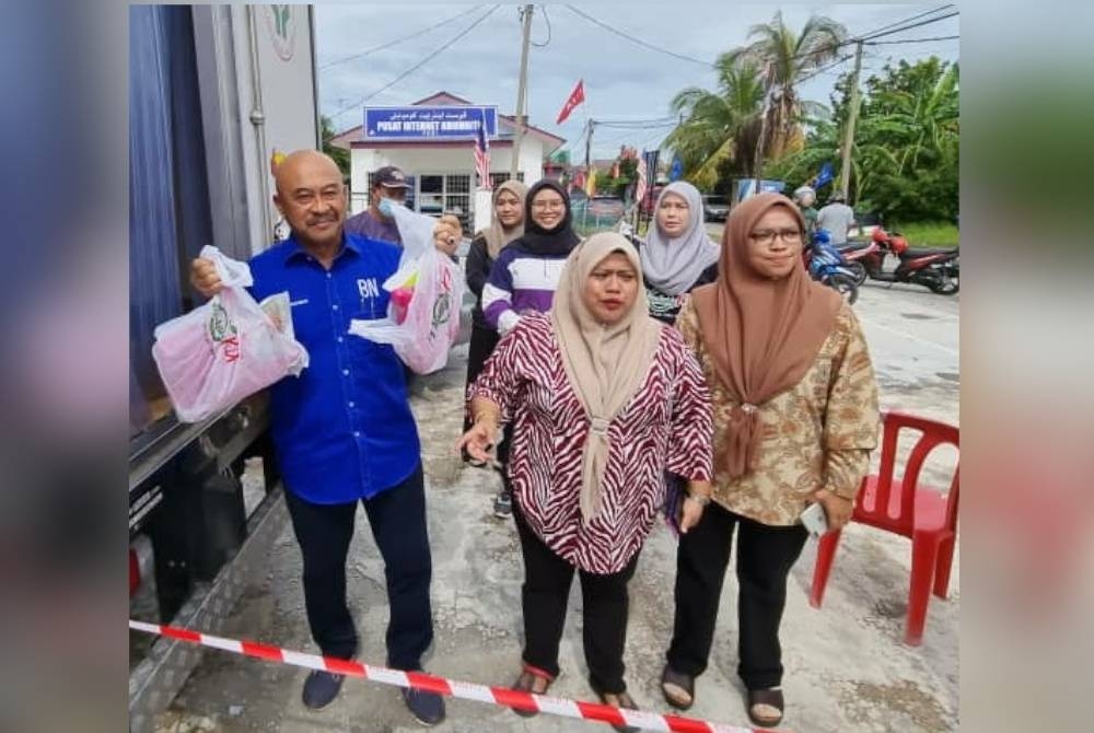 Abd Rahman (kiri) menunjukkan jualan ayam pada Program Jualan Murah Keluarga Peladang di Kampung Nelayan Sungai Besar di sini pada Khamis.