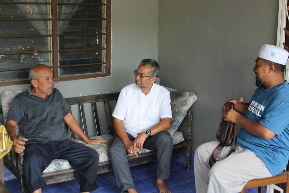 Jasri (tengah) ketika menyantuni pengundi.