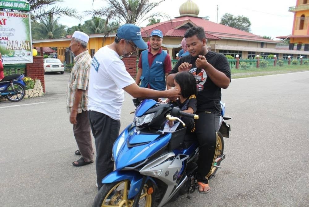 Jasri beramah mesra dengan seorang kanak-kanak ketika berkempen bertemu pengundi di kawasan DUN Kuala Sentul.