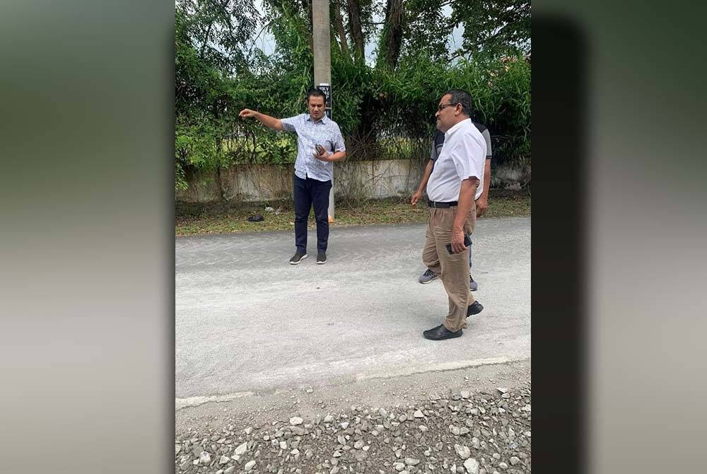 Azahar (kanan) meninjau masalah jalan berlubang dan sempit yang menjadi laluan utama penduduk Taman Kuala Perlis.