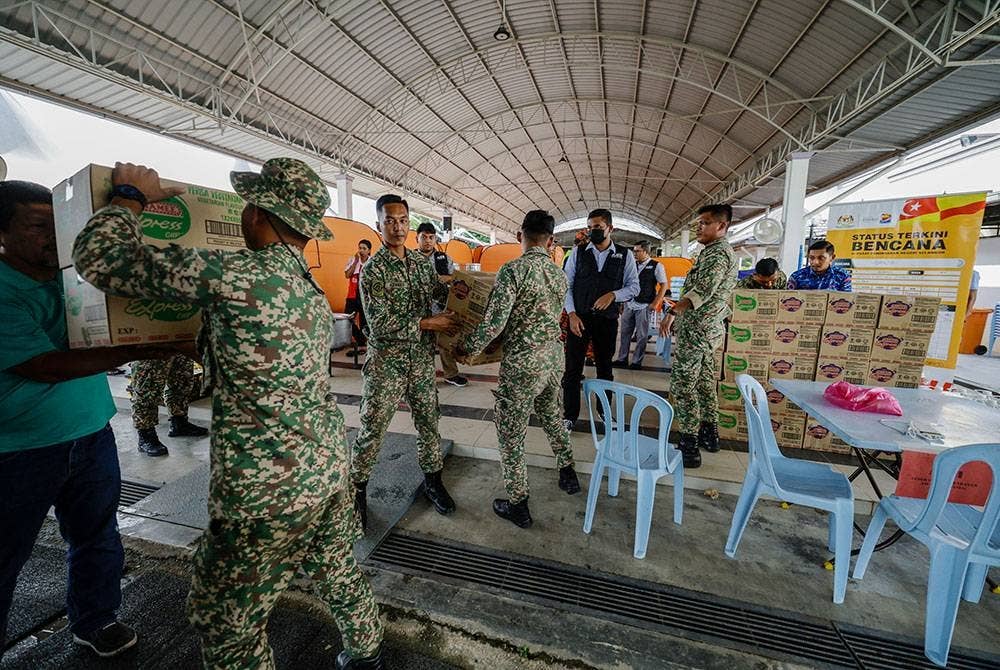 Beberapa anggota Angkatan Tentera Malaysia (ATM) membantu mengangkat sumbangan makanan yang diberikan oleh Pemerbadanan Menteri Besar (MBI) Selangor di Pusat Penempatan Sementara (PPS) Masjid Kampung Johan Setia ketika tinjauan bencana banjir yang melanda beberapa buah kawasan di Selangor, hari ini.
