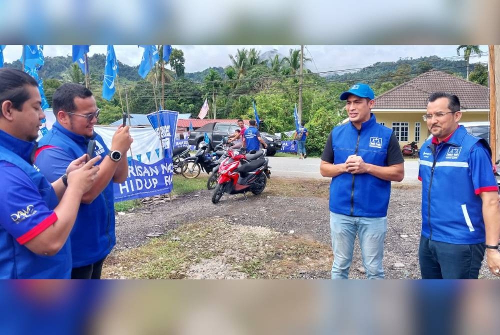 Asyraf Wajdi (kanan) ketika mengadakan kempen sebagai pecutan terakhir di Gerik pada Khamis.