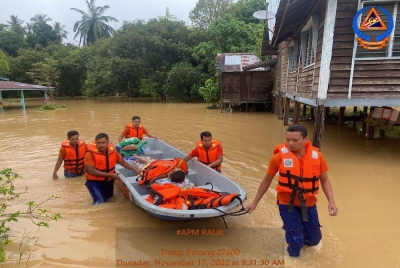 Anggota APM membantu memindahkan mangsa banjir yang melanda dua kampung di Raub pada pagi Khamis. Foto APM