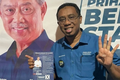 Dzulkarnain menunjukkan manifesto dan nombor calon miliknya untuk disokong oleh masyarakat di Kluang.