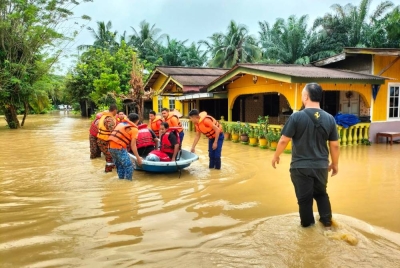Anggota APM membantu memindahkan mangsa banjir yang melanda dua kampung di Raub pada pagi Khamis. - Foto APM