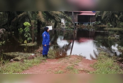 Anggota Angkatan Pertahanan Awam meninjau keadaan banjir di Kampung Ithnin Maarof, Kluang pada Rabu.