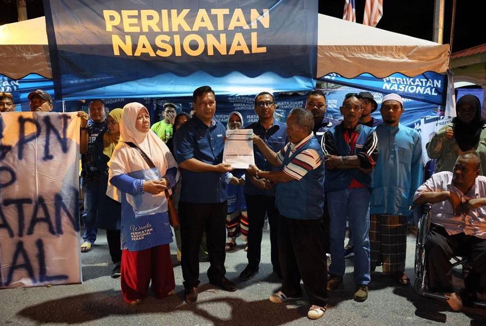 Masaad (kanan) menyerah borang keahlian menyertai Bersatu di Teluk Intan, malam ini.