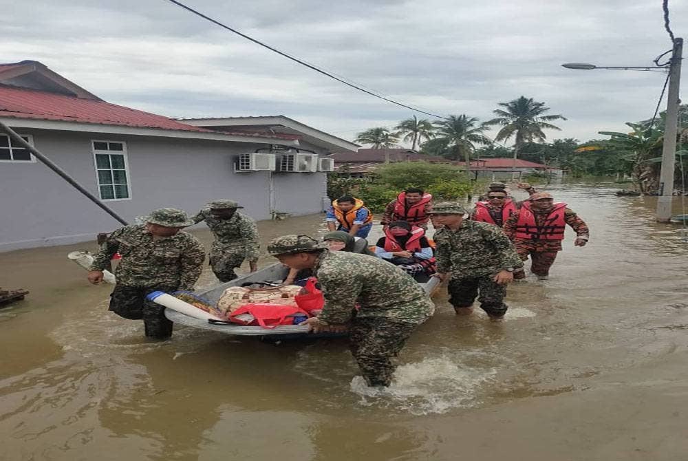 Pasukan tentera turut membantu membawa mangsa terjejas ke PPS berhampiran selepas rumah penduduk di Batu 10, Jalan Bidor, Teluk Intan dinaiki air. Foto: ihsan APM