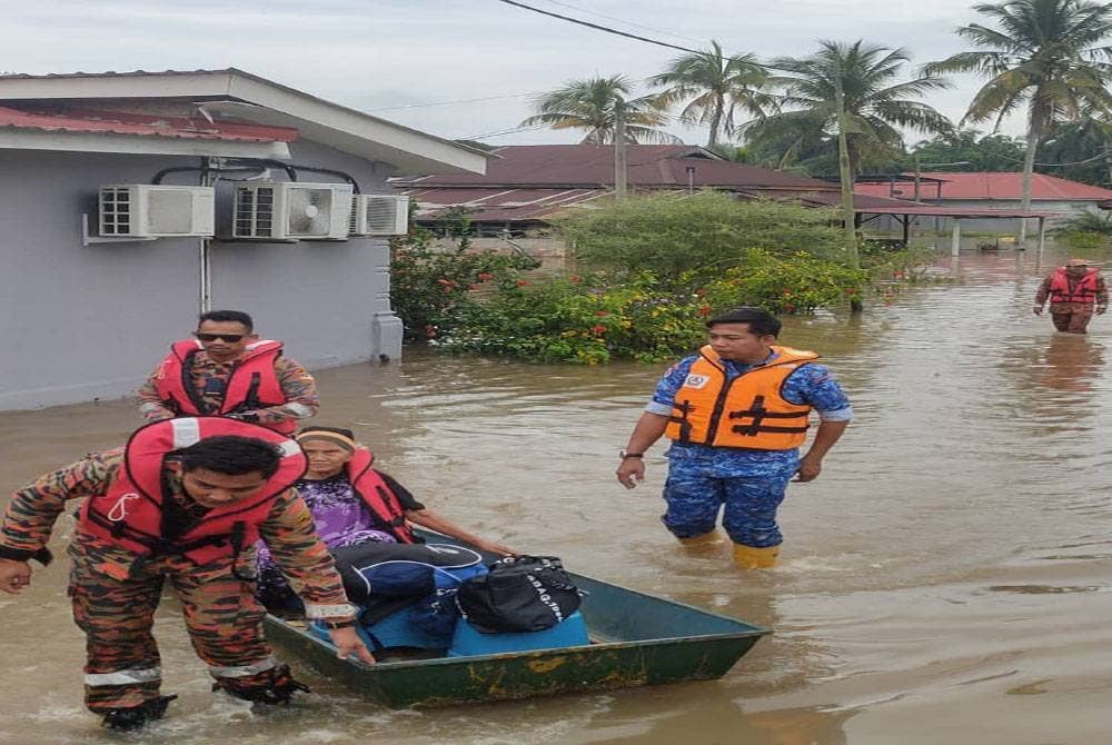 Pasukan bomba membawa keluar mangsa banjir di Jalan Bidor, Teluk Intan. Foto Ihsan Bomba Perak