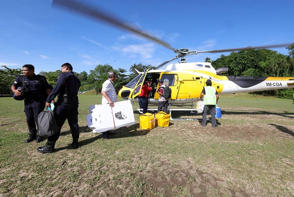 Sebahagian anggota SPR bawa peralatan mengundi untuk dihantar ke kawasan pedalaman Sabah iaitu Kampung Terian dan Kampung Buayan Penampang dengan menaiki helikopter hari ini. - Foto Bernama
