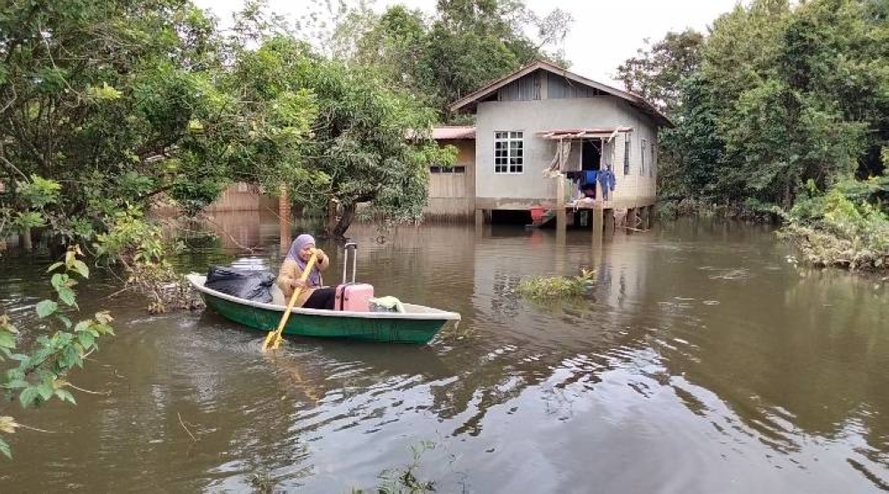 Nor Shairah mendayung perahu menuju ke rumahnya sejauh 100 meter dari jalan raya.