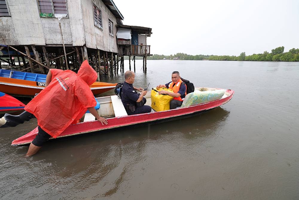Petugas Suruhanjaya Pilihan Raya (SPR) membawa peti dan kertas undi dengan menaiki bot walaupun terpaksa meredah hujan untuk ke pusat mengundi Pilihan Raya Umum Ke-15 ke Pulau Pamaguan di Kampung Batu Putih hari ini.