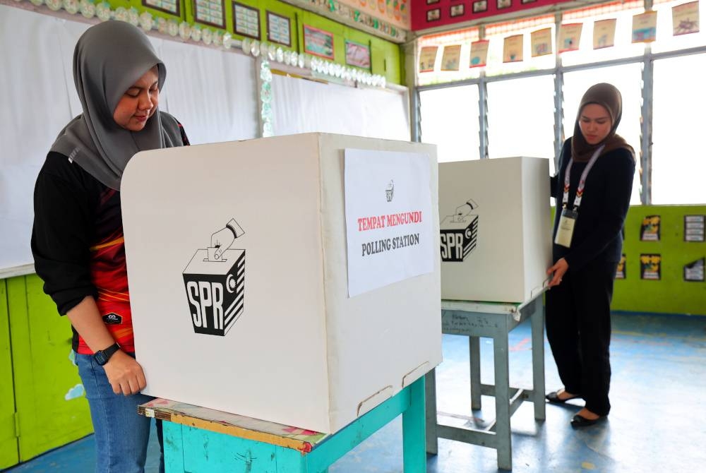 Petugas SPR menyusun peralatan untuk hari pengundian bagi P.040 Kemaman ketika tinjauan persiapan pusat mengundi di Sekolah Kebangsaan Chukai pada Jumaat. - Foto Bernama