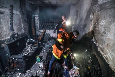 Anggota bomba memadamkan api sebuah bangunan yang musnah akibat kebakaran di kem pelarian Jabalia di Gaza. Foto AFP