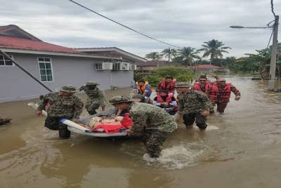 Pasukan tentera turut membantu membawa mangsa terjejas ke PPS berhampiran selepas rumah penduduk di Batu 10, Jalan Bidor, Teluk Intan dinaiki air. Foto: ihsan APM