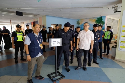 Pegawai Pengurus Pilihan Raya Parlimen Putrajaya Shamshul Joehari Zainal Mokhtar bersama A Asmadi meninjau pusat pengundian di SK Presint 9 (2) di sini. - Foto Bernama