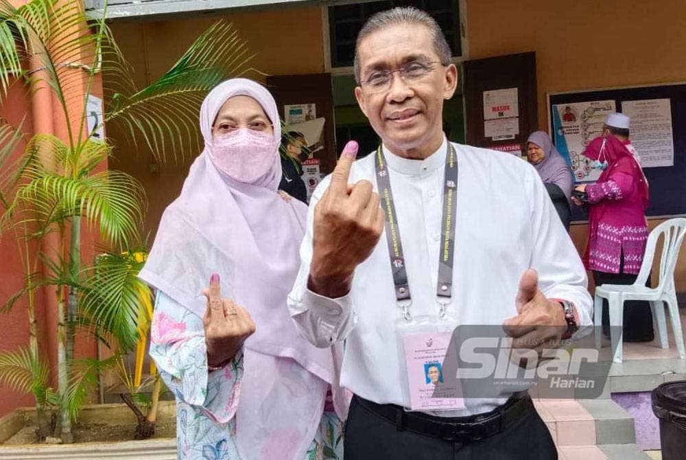 Takiyuddin bersama isteri selesai mengundi di Maktab Sultan Ismail (SIC) pada Sabtu.