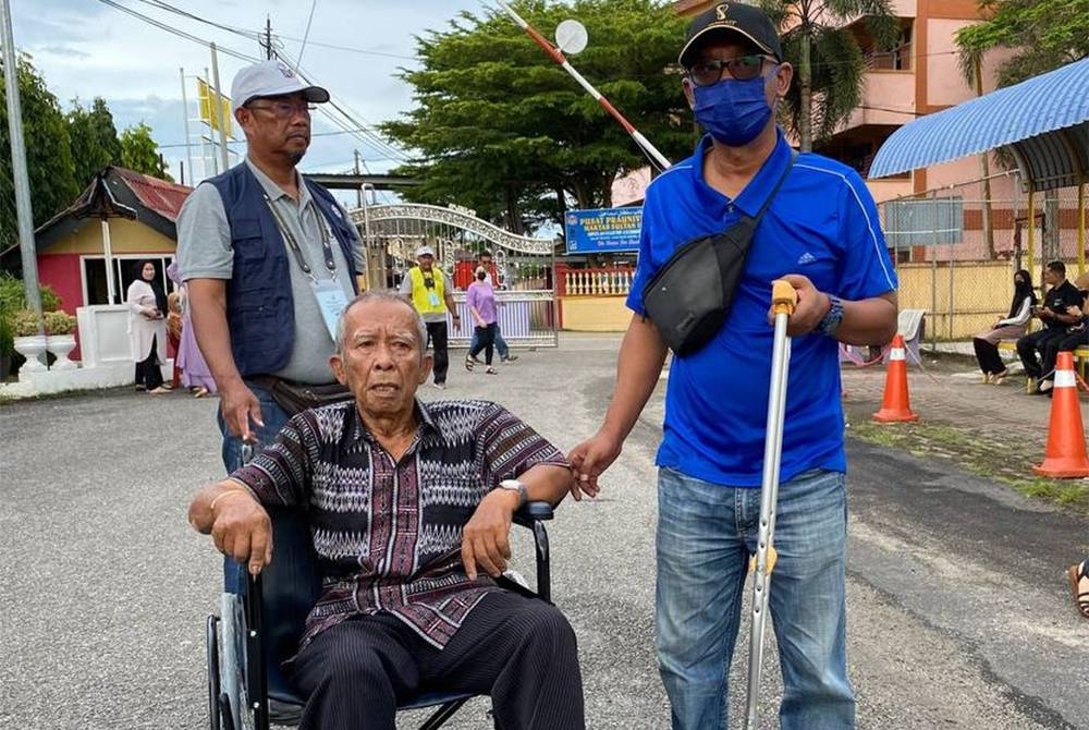 Husman@Othman sanggup berkerusi roda hadir ke pusat pengundian di Maktab Sultan Ismail (SIC) di Kota Bharu pada Sabtu untuk mengundi kali ke-15.