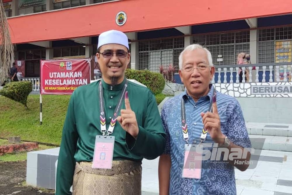Nurul Amin (kiri) dan Mahdzir selesai membuang undi PRU15 di SK Naka, Padang Terap pada pagi Sabtu.