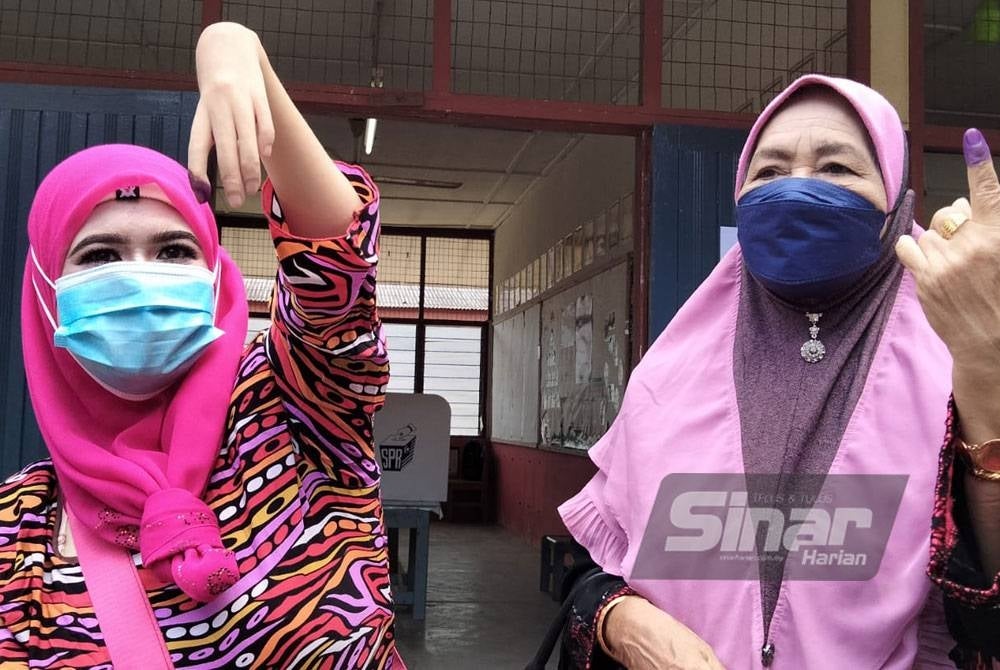 Zauyah dan Fatimah menunjukkan jarinya selepas mengundi di SK Padang Mandol.