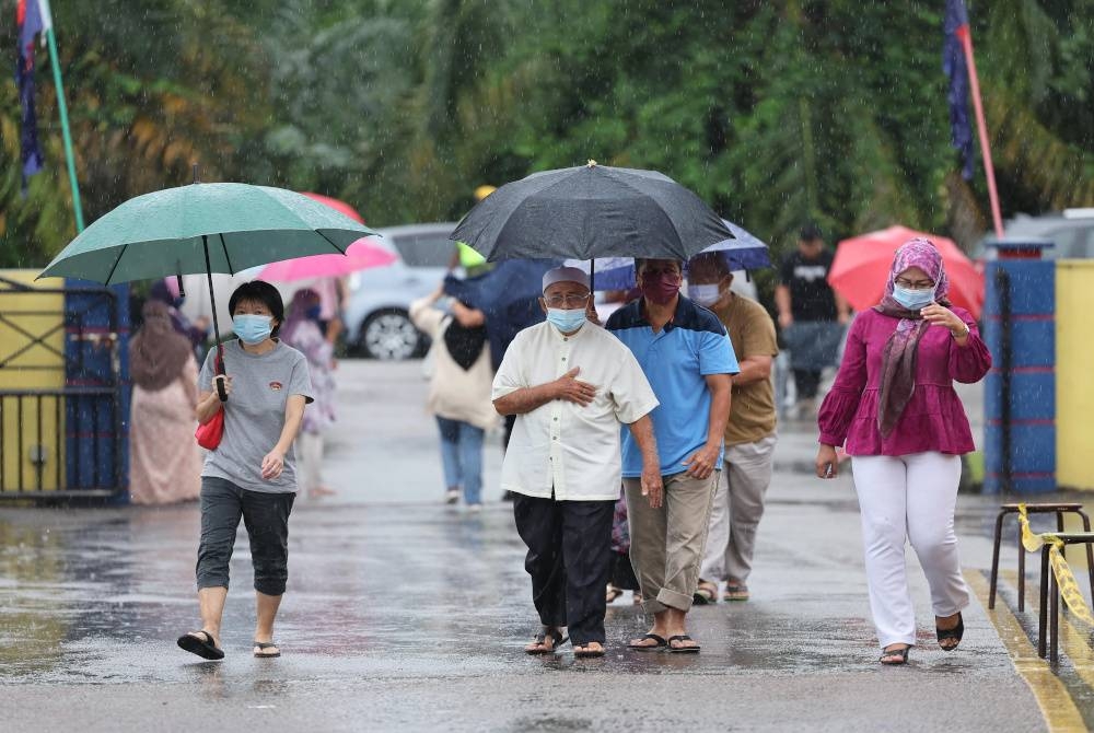 Hujan tidak menghalang orang ramai untuk keluar menunaikan tanggungjawab mengundi pada PRU15. - Foto Bernama