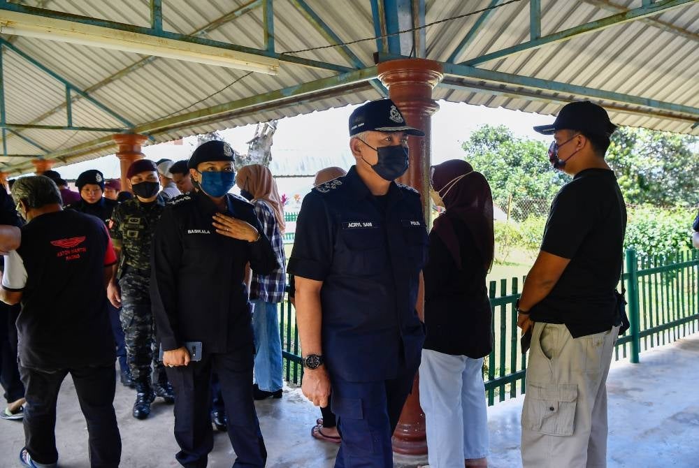 Acryl Sani (tiga, kanan) meninjau pusat pengundian di Sekolah Kebangsaan Sungai Kertas pada Sabtu. - Foto Bernama