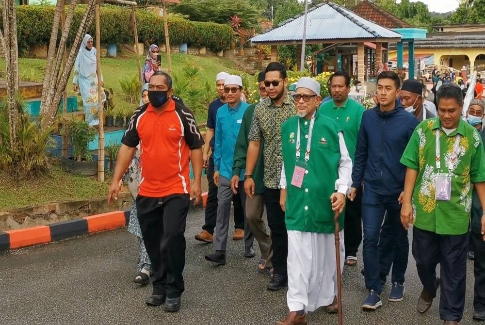 Abdul Hadi (depan) ketika hadir ke pusat pembuangan undi di SK Rusila, Marang pada pagi Sabtu.