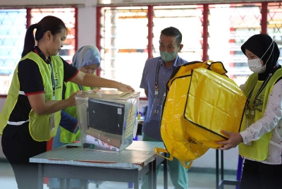Petugas SPR menyiapkan peti undi di hadapan agen calon sebelum bermulanya proses pengundian PRU15 di Sekolah Menengah Kebangsaan Bukit Garam hari ini. - Foto Bernama