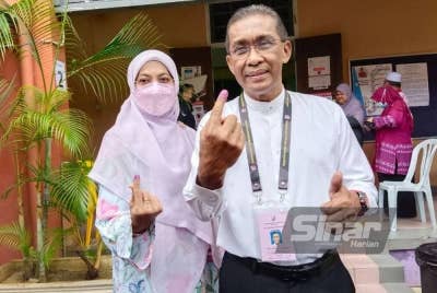 Takiyuddin bersama isteri selesai mengundi di Maktab Sultan Ismail (SIC) pada Sabtu.