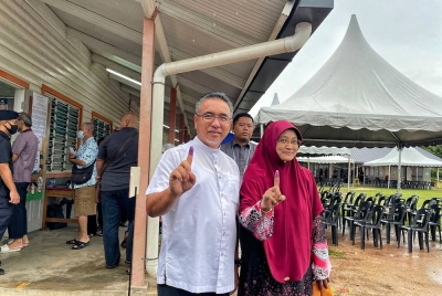 Adly (kiri) bersama isterinya, Dalilah Awaludin selesai membuang undi di pusat pengundian Sekolah Kebangsaan Durian Tunggal pada jam 9.16 pagi.