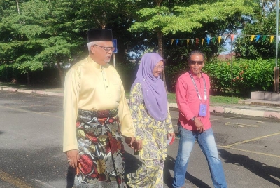 Mahfuz tiba bersama isteri menunaikan tanggungjawab mengundi pada PRU15 di Kolej Tingkatan Enam Sultan Sallehuddin di Hutan Kampung, di sini, pada Sabtu.