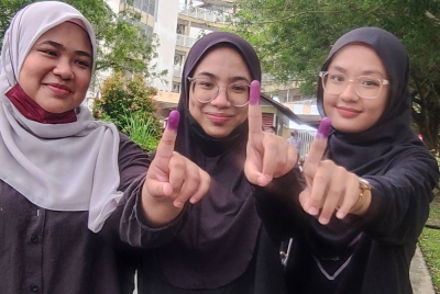 Tiga beradik dari kiri, Siti Zaimah, Aini salamah dan Aina Shakirah menunjukkan jari dicelup dakwat pilihan raya.