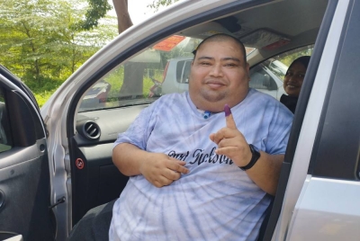 Mohd Fahmi menunjukkan jari berdakwat biru setelah selesai menjalankan tanggungjawab kepada negara di hadapan Pusat Pembuangan Undi Sekolah Kebangsaan Bukit Sagu 1, Kuantan pada Sabtu.