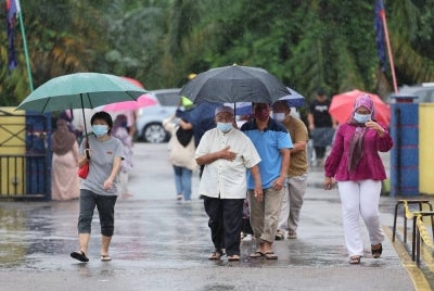Hujan tidak menghalang orang ramai untuk keluar menunaikan tanggungjawab mengundi pada PRU15. - Foto Bernama