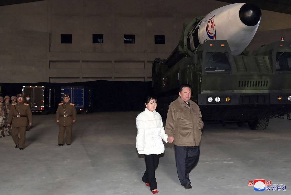 Jong-un (kanan) memimpin tangan putrinya saat dia memeriksa ICBM baru, Hwasong Gun 17 sebelum peluncuran uji coba.  - Foto AFP
