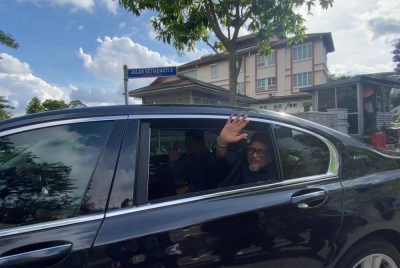 Abdul Hadi melambaikan tangan kepada petugas media yang menanti di luar kediaman Muhyiddin.