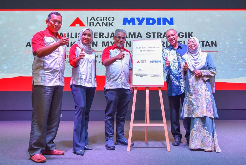 Tengku Ahmad Badli Shah (tiga dari kiri) dan Ameer (dua dari kanan) menandatangani satu perjanjian kerjasama strategik bagi membantu mengembangkan perniagaan pemborong Mydin Kelantan dengan menawarkan kemudahan pembiayaan modal kerja sehingga RM500,000.