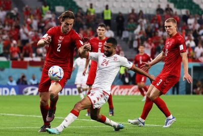 Pemain Tunisia, Ali Abdi (tengah) cuba melepasi kawalan pemain Denmark. - Foto EPA.