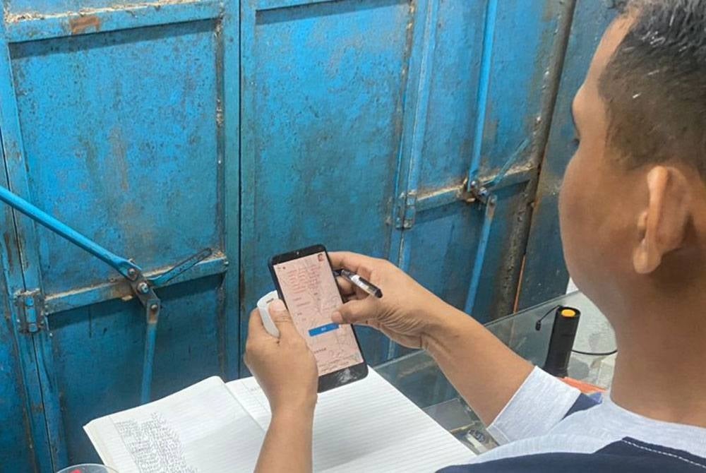 Anggota polis memeriksa telefon bimbit yang dipercayai digunakan dalam aktiviti pertaruhan judi Piala Dunia 2022.