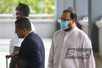 Muzzamil (kanan) ketika tiba di mahkamah pada Rabu.