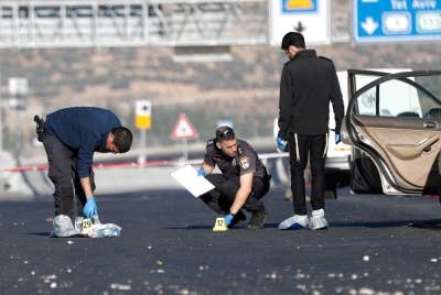 Pasukan keselamatan Israel berdiri di lokasi letupan di perhentian bas berhampiran pintu masuk ke Baitulmaqdis pada Rabu. - Foto EPA