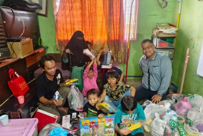 Mas Imran (kanan) menyampaikan sumbangan kepada keluarga Mohd Hassan di PPR Sri Stulang, Johor Bahru.
