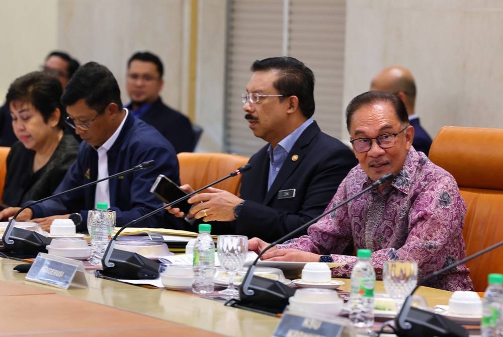 Anwar (kanan) mempengerusikan Mesyuarat Khas Majlis Tindakan Sara Hidup Negara di Bangunan Perdana Putra pada Ahad. - Foto Bernama