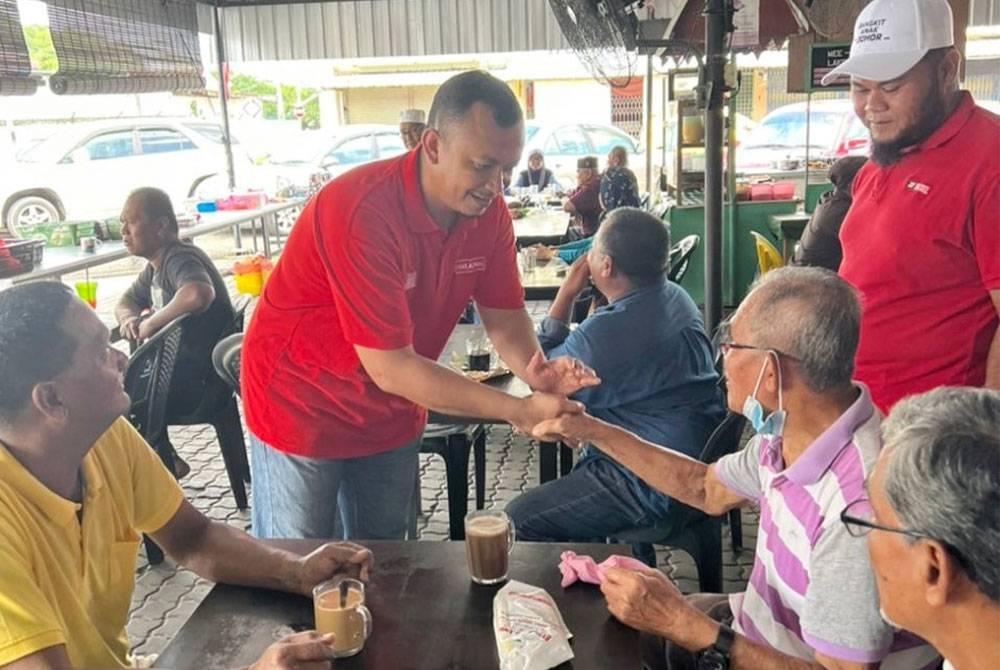 Mohd Fadzli (tengah) bersama dengan masyarakat di DUN Tioman ketika mengadakan kempen PRU15 pada Ahad.